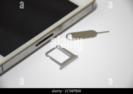 Soft Focus to SIM card or Subscriber identity module and SIM Ejector Tool From Smartphone Stock Photo
