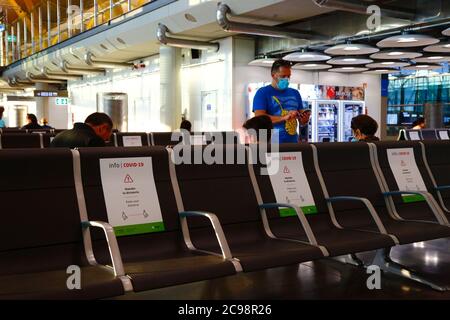 28th July 2020, Barajas Airport, Madrid, Spain: Signs on seats to help passengers comply with social distancing in the near empy departure lounge area of the Terminal 4S building of Barajas Airport. Reduced numbers of flights are now operating between European countries after the lockdown to control the covid-19 coronavirus, and governments have put a system of air bridges in place to facilitate travel and tourism. Spain has seen a number of new outbreaks in recent days, prompting the UK government to announce that people returning to the UK from Spain should quarantine for 14 days on arrival. Stock Photo