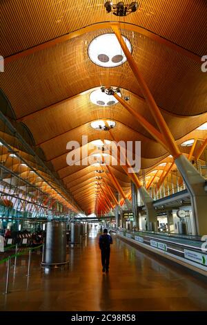 28th July 2020, Barajas Airport, Madrid, Spain: A passenger walks through the near empy departure gates lounge area of the Terminal 4S building of Barajas Airport. Reduced numbers of flights are now operating between European countries after the lockdown to control the covid-19 coronavirus, and governments have put a system of air bridges in place to facilitate travel and tourism. Spain has seen a number of new outbreaks in recent days, prompting the UK government to announce that people returning to the UK from Spain should quarantine for 14 days on arrival. Stock Photo