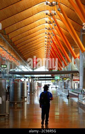 28th July 2020, Barajas Airport, Madrid, Spain: A passenger walks through the near empy departure gates lounge area of the Terminal 4S building of Barajas Airport. Reduced numbers of flights are now operating between European countries after the lockdown to control the covid-19 coronavirus, and governments have put a system of air bridges in place to facilitate travel and tourism. Spain has seen a number of new outbreaks in recent days, prompting the UK government to announce that people returning to the UK from Spain should quarantine for 14 days on arrival. Stock Photo