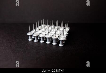 pins and stationery on a black background, closeup Stock Photo