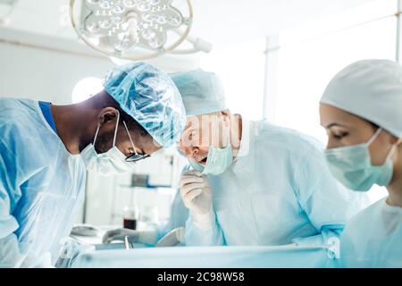 scared doctor is looking at the patient during the operation. emotion and feeling concepts , close up side view photo Stock Photo