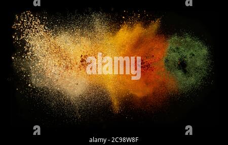 Freeze motion of various spice explosion, abstract culinary background. Isolated on black background Stock Photo
