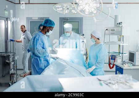 Experienced African doctor and his team perform the surgery with modern technologies in the clinic . Stock Photo