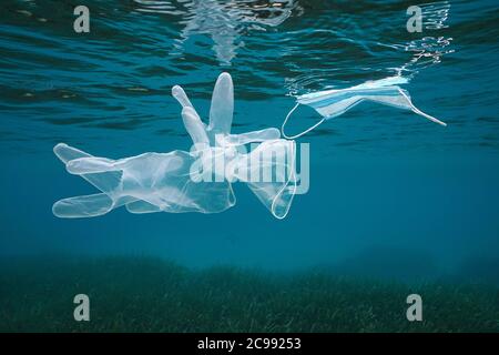 Gloves and face mask underwater in the sea, plastic waste pollution since coronavirus COVID-19 pandemic, Mediterranean sea