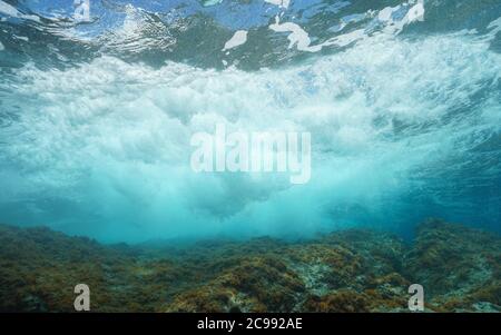 Sea wave breaking on rock under water surface, Mediterranean sea Stock Photo