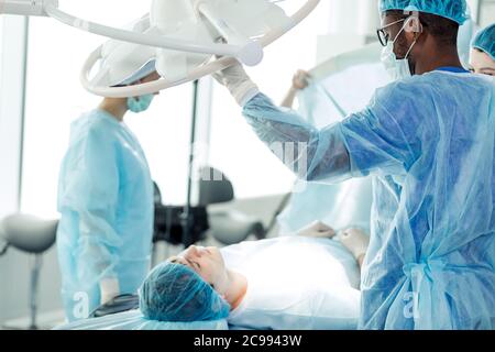 Surgeons operates the patient lying under anesthesia in the clinic. close up photo.african man watching the sleeping client. health care concept Stock Photo
