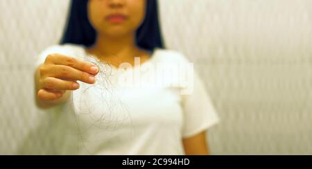 Soft focus to Young woman with hair loss problem on hand in Toilet with copyspace. - Alopecia areata Stock Photo