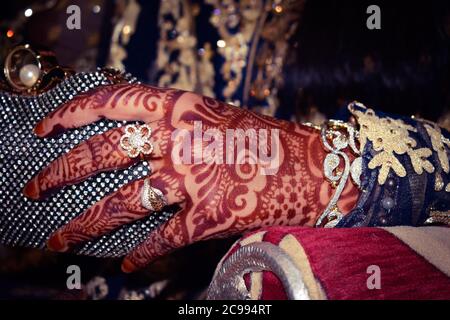 Beautiful henna on bride's hand. Indian marraiges and pakistani marraige. Woman hand with gold rings Stock Photo