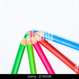 Pattern made with five different colored wood pencil crayons on a paper background Stock Photo