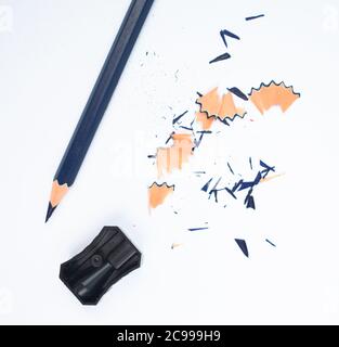 Some study materials containing a blue pencil and a single black color plastic sharpener Stock Photo