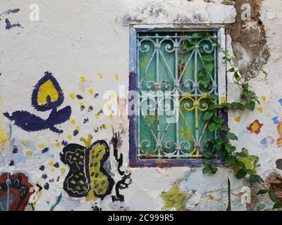 Old green window on a colored wall in Asilah medina, Morocco. Stock Photo