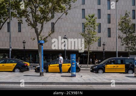 Barcelona, Spain. 29th July, 2020. Several taxis parked without clients at the Aero Bus airport stop in Plaza Catalunya during the Coronavirus outbreak.After the veto to travel to Spain due to the outbreaks of Covid-19, especially to Catalonia, by the governments of the United Kingdom, Germany and the Netherlands, Barcelona shows a total decline in tourists visiting the city that seriously affects sales in shops, bars and restaurants. Credit: SOPA Images Limited/Alamy Live News Stock Photo