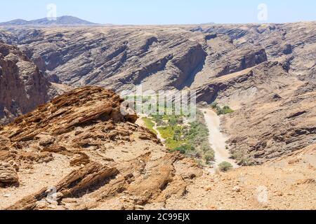 Typical bleak, arid stratified rock mountainous terrain and dried-up riverbed in the Namib Desert on the Skeleton Coast, Namibia, south-west Africa Stock Photo