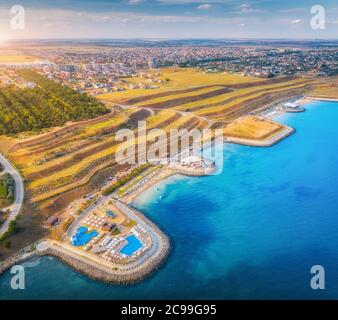 Aerial view of sandy beach, blue sea, restaurants at sunset Stock Photo