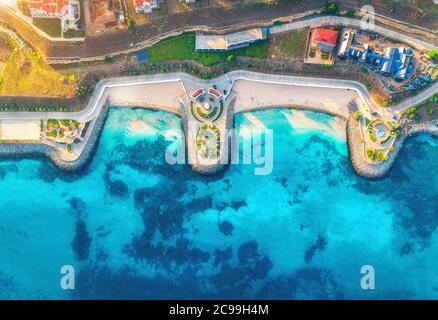 Aerial view of sandy beach, blue sea, restaurants at sunset Stock Photo