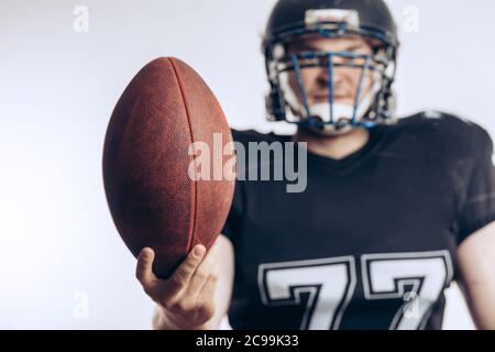 Sport, Healthy Lifestyle and People concept. American football player wearing black jersey and head gear giving u in game support of England national Stock Photo