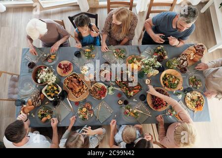 High angle view of big family sitting at the table and having dinner together at home Stock Photo