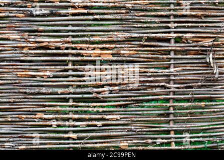 Texture and background of a wicker fence made of old weathered branches, copy space. Stock Photo