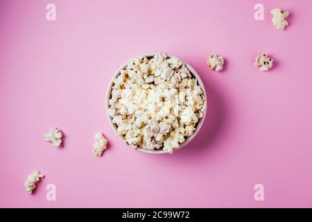 A pink bowl of popcorn on pink background, top view Stock Photo