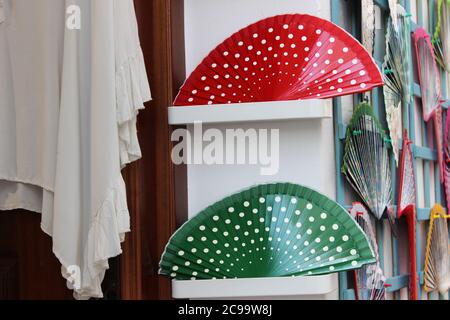 Close up shot of red and green handheld folding fans in polka dot pattern in a store Stock Photo