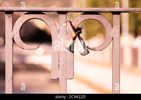 Old love locks hanging on a metal fence in a park Stock Photo
