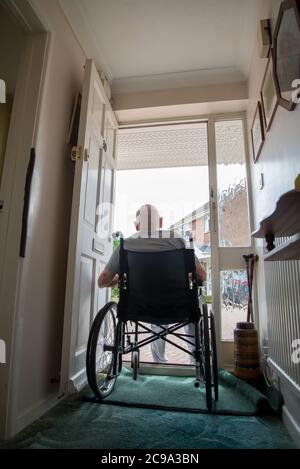 Rear view of elderly male in his nineties,with dementia,unable to leave the house due to risk of Covoid-19 infection,likes to sit in his doorway when Stock Photo