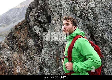 Hiker - man hiking in mountains. Adventure outdoor lifestyle. Male hiker looking to the side walking in forest. Caucasian person portrait outdoors in Stock Photo