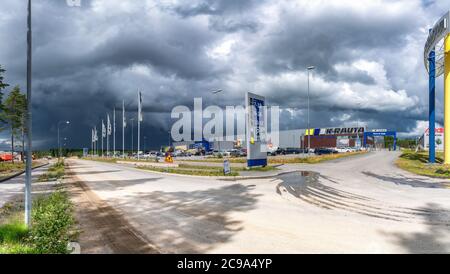 Umea, Sweden - JULY 09, 2020: K-Rauta, building materials shop and parking lot under heavy summer clouds, just before heavy rain. Logo of K-Rauta on t Stock Photo