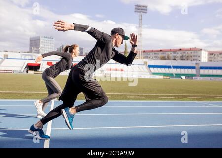 Young running couple . full length side view shot.willpower, strength, determination concept. copy space. contest concept Stock Photo