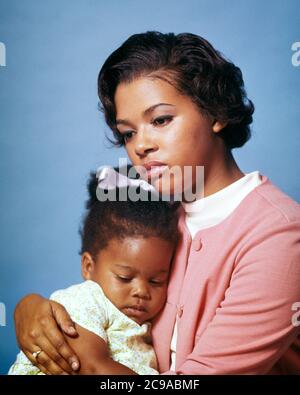1970s CONCERNED AFRICAN-AMERICAN MOTHER SERIOUS EXPRESSION HOLDING HUGGING COMFORTING YOUNG TODDLER DAUGHTER SLEEPING IN ARMS - kj5655 PHT001 HARS DEPRESSION COLOR MOTHERS EXPRESSION OLD TIME NOSTALGIA OLD FASHION 1 COMFORTING JUVENILE FACIAL COMMUNICATION YOUNG ADULT SAFETY WORRY FAMILIES LIFESTYLE PARENTING FEMALES STUDIO SHOT MOODY HOME LIFE COPY SPACE HALF-LENGTH LADIES DAUGHTERS PERSONS THOUGHTFUL INSPIRATION CARING RISK EXPRESSIONS TROUBLED CONCERNED SADNESS PROTECTING AFRICAN-AMERICANS AFRICAN-AMERICAN BLACK ETHNICITY MOOD CONNECTION GLUM SINCERE SOLEMN COOPERATION FOCUSED INTENSE Stock Photo