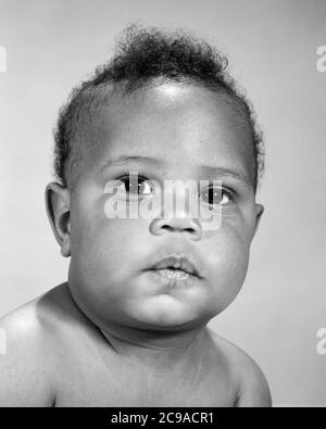 1960s PORTRAIT OF SERIOUS AFRICAN AMERICAN BABY BOY WITH POUTING QUESTIONING FACIAL EXPRESSION LOOKING AT CAMERA - n2168 HAR001 HARS EXPRESSIONS B&W SADNESS EYE CONTACT HEAD AND SHOULDERS POUTING AFRICAN-AMERICANS AFRICAN-AMERICAN CHEEKS BLACK ETHNICITY CONCEPTUAL SINCERE BABY BOY SOLEMN FOCUSED GROWTH INTENSE JUVENILES QUESTIONING BLACK AND WHITE CAREFUL EARNEST HAR001 INTENT OLD FASHIONED AFRICAN AMERICANS Stock Photo