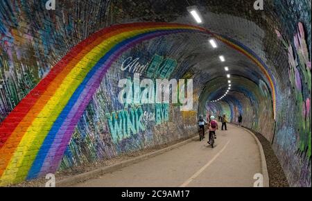 cyclists on the Water of Leith Walkway cycling past the rainbow mural in  Colinton Tunnel, Edinburgh, Scotland, UK Stock Photo