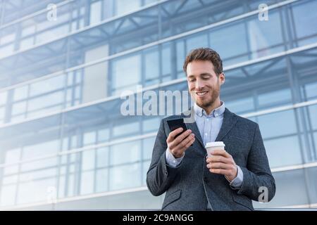 Businessman holding mobile phone using app texting Stock Photo