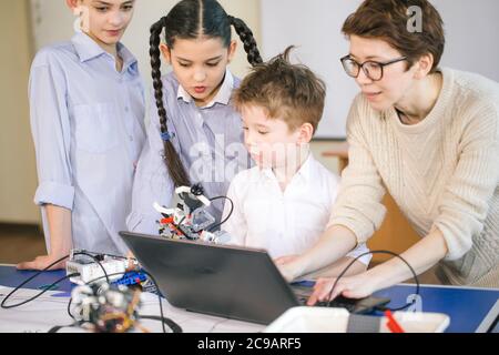 Smart kids with their mother learn programming using laptop at home, science children creativity study concept Stock Photo