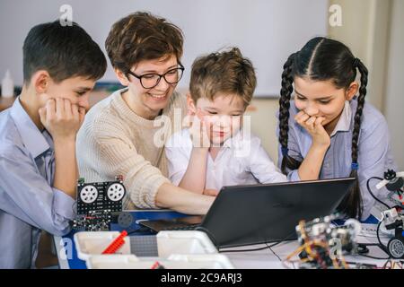 Smart kids with their mother learn programming using laptop at home, science children creativity study concept Stock Photo