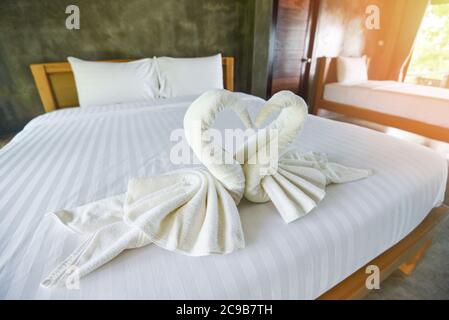 White clean bath towel on bed decoration interior of bedroom / White towel on bed in guest room for hotel customer Stock Photo