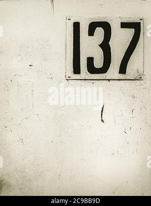 old house address number plate on white wall Stock Photo
