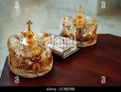 Two crowns and bible on holy altar for the wedding ceremony in the Russian Stock Photo