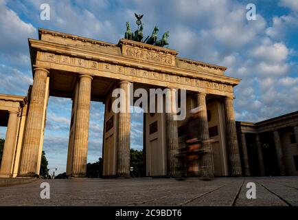 Berlin, Germany. 30th July, 2020. A cyclist rides through the Brandenburg Gate in the early morning. Credit: Fabian Sommer/dpa/Alamy Live News Stock Photo