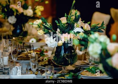 Beautiful bouquet of flowers at the wedding table in a restaurant for holidays and wedding dinner Stock Photo