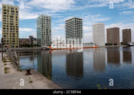 Antwerp, Belgium, July 19, 2020, River cruise ship with apartment buildings and reflection on the water Stock Photo