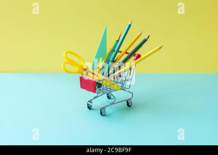 Turquoise yellow stationery in food basket on turquoise and yellow. Hipster minimal concept. Front view. Stock Photo