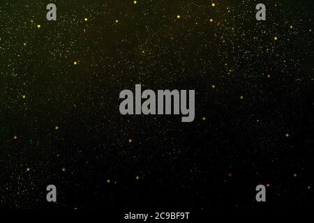 Golden stars and sparkles on black background. Starry sky. Stock Photo