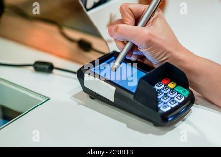 Close up video of woman's hand entering information on credit card reader in shop Stock Photo