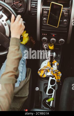 inside of the car with little women things sunglasses lipstick phone at phone holder. Stock Photo