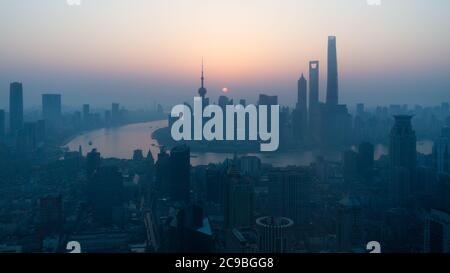 Sun rising above the Shanghai skyline. With skyscrapers and Huangpu River. Stock Photo