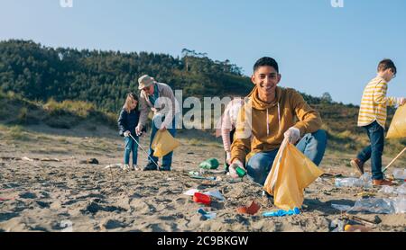 Young man cleaning the beach Stock Photo