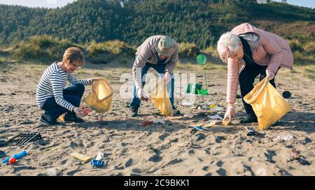 Senior volunteers cleaning the beach Stock Photo