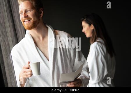 Young man in bathrobe drinking coffee at home Stock Photo